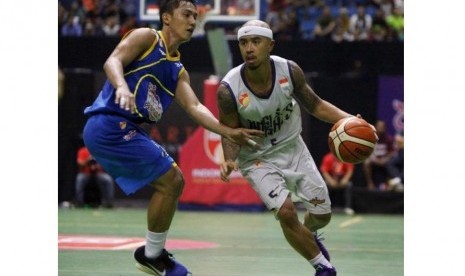 Point guard Satria Muda Pertamina Hardianus Lakudu (kir) menjaga point guardCLS Knights Mario Wuysang.