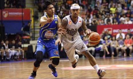 Point guard Satria Muda Pertamina Hardianus Lakudu (kiri) menjaga pointguard CLS Knights Mario Wuysang.