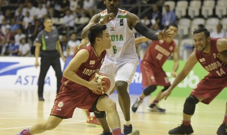 Point guard timnas basket putra Indonesia Andakara Prastawa Dhyaksa (kiri) mencoba melewati adangan pebasket India Aravind Annadurai (kedua kiri) saat laga final bola basket Turnamen Invitasi Asian Games 2018 di Hall Basket Senayan, Jakarta, Senin (12/2)