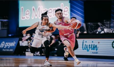 Point guard West Bandits Solo Widyanta Putra Teja berebut bola dengan point guard Prawira Bandung Arif Hidayat dalam pertandingan pertama play-off IBL 2021 di Mahaka Arena, Jakarta, Ahad (23/5)..