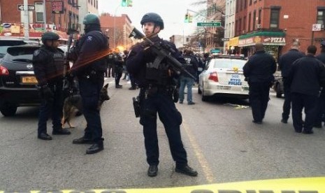 Police officers block off the scene of a a shooting incident where a gunman killed two New York police officers as they sat in their squad car before turning his weapon on himself in New York December 20, 2014.