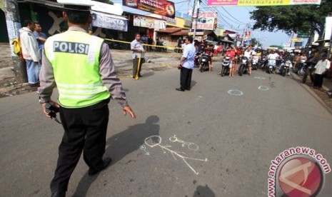 Police officers mark and install police lines in the accident site where one policeman got shot until dead in Jalan Otto Iskandar Dinata, Tangerang, Banten Province. The victim was First Adjunct Police Inspector Dwijatna. 