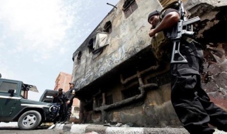 Police officers stand in front of a police station damaged after being set ablaze in August by supporters of former president Mohamed Mursi in Kerdasa, 9 miles from Cairo September 19, 2013.