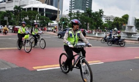 Police officers use bikes in MH Thamrin Street, where the car free night takes place on the new year's eve, tonight. The police deploy 9,000 personnel to secure the event.   