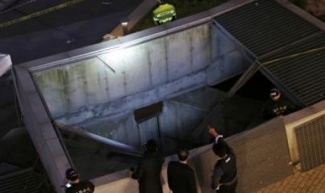 Police officials examine the scene of an accident at a shopping district in Seongnam October 17, 2014. 