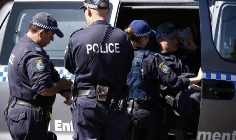 Police talk outside a house that was involved in pre-dawn raids in the western Sydney suburb of Guilford September 18, 2014.