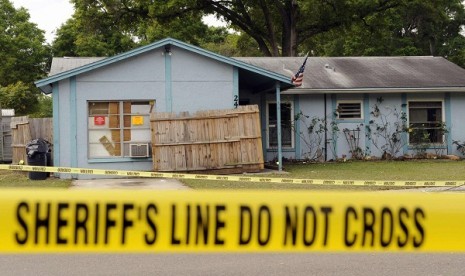 Police tape surrounds a home where a sinkhole opened up and swallowed a Florida man in Seffner, Florida, March 1, 2013. 