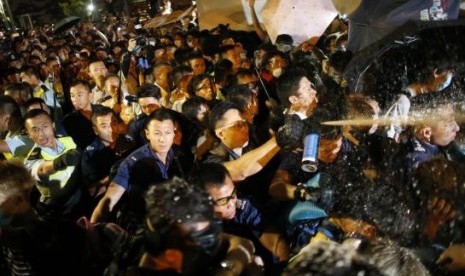 Police use pepper spray as they clash with pro-democracy protesters at an area near the government headquarters building in Hong Kong early October 16, 2014.  