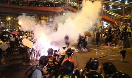 Polisi Anti Huru Hara menembakkan gas air mata kepada demonstran yang melakukan kampanye di Hong Kong, Ahad (21/7)