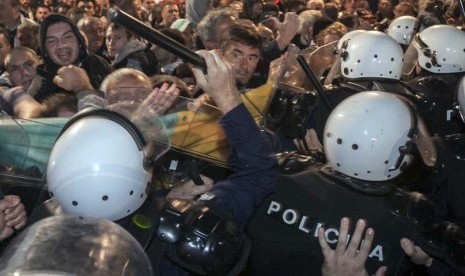 Polisi antihuru-hara terlibat bentrok dengan demonstran di depan gedung parlemen di ibukota Podgorica, Montenegro, Sabtu (17/10). 