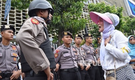 Polisi berdialog dengan salah satu pengunjuk rasa menuntut diusutnya dugaan kecurangan Pemilu 2019 di Kantor Bawaslu RI, Jakarta, Kamis (9/5). 