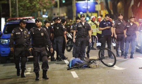 Polisi berdiri dekat jasad pria yang tertembak dan tewas dekat Stadion Maracana usai upacara pembukaan Olimpiade Musim Panas 2016 di Rio de Janeiro, Brasil, Sabtu, 6 Agustus 2016.