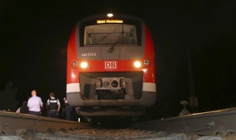 Polisi berdiri dekat sebuah kereta di Wuerzburg, selatan Jerman, Senin malam, 18 Juli 2016. Terjadi serangan kapak di kereta itu yang melukai empat orang.