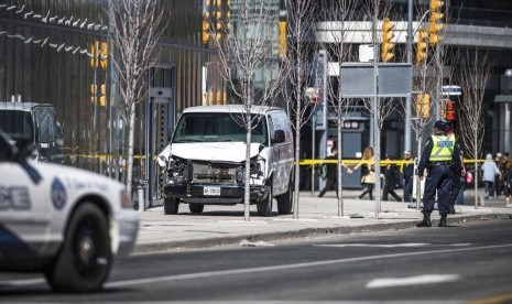 Polisi berdiri di dekat van yang digunakan pelaku untuk menabrak pejalan kaki di Toronto, Kanada, Senin (23/4)