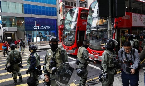 Polisi berjaga di depan halte bus di Hong Kong. PM Li Keqiang menyebut RUU ekstradisi merusak seluruh lapisan masyarakat Hong Kong. Ilustrasi.