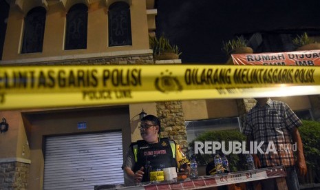 Polisi berjaga di depan sebuah rumah usai penangkapan terduga teroris di kawasan Dukuh Pakis, Surabaya, Jawa Timur, Selasa (15/5).