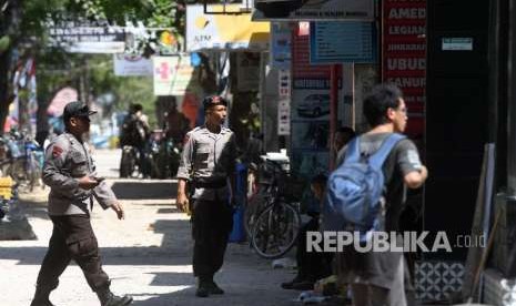 Polisi berjaga di depan toko yang tutup di Gili Trawangan, Lombok Utara, NTB, Kamis (9/8). 