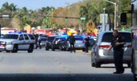 Polisi berjaga di halaman sekolah SMA di Florida yang mengalami penyerangan.