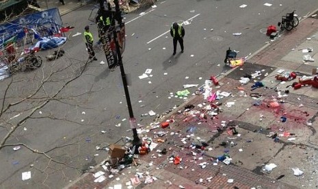 Polisi berjaga di lokasi ledakan dua bom kembar di dekat garis finis perlombaan Maraton Boston 2013, Senin 15 April 2013