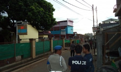 Polisi berjaga di lokasi penggerebakan sebuah rumah di Bintara Jaya, Bekasi, Sabtu (10/12). Di rumah bertingkat tiga bercat biru dan pink itu ditemukan benda diduga bom.