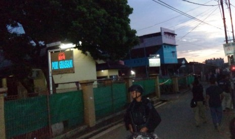 Polisi berjaga di lokasi penggerebakan sebuah rumah di Bintara Jaya, Bekasi, Sabtu (10/12). Di rumah bertingkat tiga bercat biru dan pink ditemukan benda diduga bom.