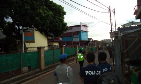 Polisi berjaga di lokasi penggerebakan sebuah rumah di Bintara Jaya, Bekasi, Sabtu (10/12). Di rumah bertingkat tiga bercat biru dan pink ditemukan benda diduga bom.