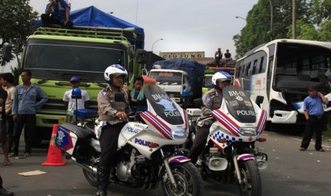  Polisi berjaga diantara kemacetan panjang kendaraan dari Serang menuju Jakarta yang macet total akibat diblokir buruh di gerbang Tol Jakarta-Merak KM-57, Ciujung, Serang, Banten, Selasa (3/12).  (Antara/Asep 