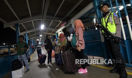 Polisi berjaga diantara para pemudik di Pelabuhan Merak, Banten.