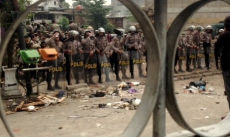 Polisi berjaga dilokasi kericuhan relokasi Kampung Pulo, Jakarta Timur