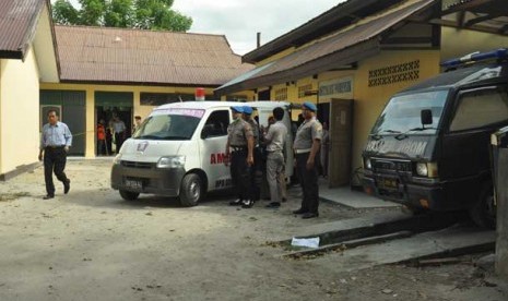  Polisi berjaga disekitar ambulance yang membawa jenazah terduga teroris saat akan dibawa pihak keluarga ke Kabupaten Poso dari RS Bhayangkara Palu, Sulawesi Tengah, Selasa (11/6). 