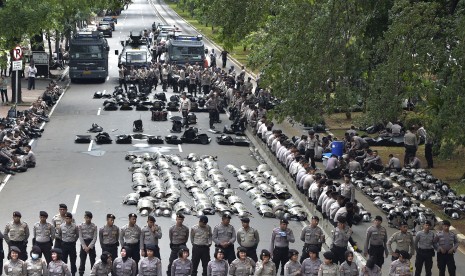 Polisi berjaga-jaga sebagai bagian dari pengamanan Aksi 313 di Jalan Medan Merdeka Barat, Jakarta, Jumat (31/3).