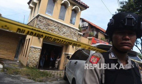 Polisi berjaga saat berlangsung penggeledahan di rumah terduga teroris di kawasan Dukuh Pakis, Surabaya, Jawa Timur, Kamis (17/5). 