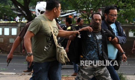 Polisi berpakaian sipil mengamankan seorang anggota ormas yang terlibat bentrok di Jalan Raya Kalimalang, Tambun Selatan, Bekasi, Jawa Barat. (Ilustrasi)