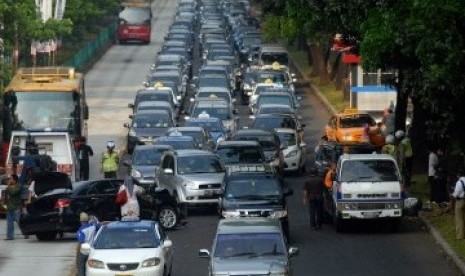 Polisi bersama pengguna jalan membantu mengurai kemacetan akibat kecelakaan lalulintas dikawasan Jalan Jenderal Sudirman, Jakarta Selatan, Rabu (20/4). Mobil derek mencoba menarik mobil yang 