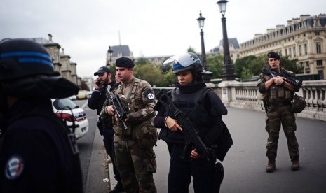 Polisi bersenjata dan tentara berjaga setelah penikaman polisi di markas polisi di Paris, Kamis (3/10). Insiden itu menewaskan empat polisi.