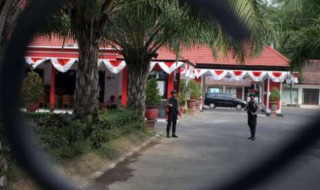 Polisi bersenjata lengkap berjaga di halaman Rumah Dinas (Rumdin) Wali Kota Blitar saat penyidik KPK melakukan penggeledahan lanjutan di Kota Blitar, Jawa Timur, Selasa (4/9). 