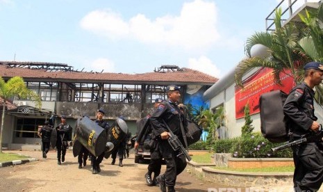 Polisi bersenjata lengkap bersiap melakukan penjagaan ketat pasca kebakaran yang terjadi di Lembaga Pemasyarakatan Kelas IIA Banceuy, Kota Bandung, Ahad (24/4). (Republika/Dede Lukman Hakim)