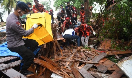 Polisi dan relawan mengevakuasi korban tewas akibat Tsunami yang tertimbun di bawah reruntuhan di kawasan Carita, Banten, Senin (24/12/2018).