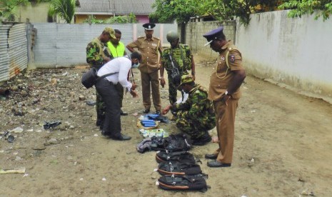 Polisi dan tentara Sri Lanka memperlihatkan bahan pembuat bom dari tempat persembunyian militan saat baku tembak di Sri Lanka, Sabtu (27/4).