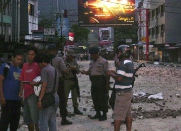 Polisi dan warga berada di lokasi bekas-bekas kerusuhan di Kota Ambon