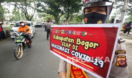 Polisi dari Polres Bogor mensosialisasikan vaksinasi COVID-19 di Jalan Raya Tegar Beriman, Cibinong, Kabupaten Bogor, Jawa Barat, Selasa (26/1/2021). Sosialisasi tersebut mengajak masyarakat untuk tidak takut melakukan vaksinasi COVID-19 yang disediakan oleh pemerintah. 