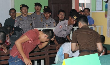 Polisi dari satuan Polres Rejang Lebong mengawal tujuh terdakwa anak kasus pemerkosaan YY saat memasuki ruang sidang anak di Pengadilan Negeri Curup, Rejang Lebong, Bengkulu, Selasa (10/5).