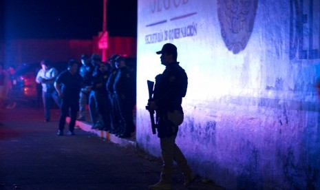 Polisi federal Meksiko berjaga di luar pusat penahanan imigrasi di Tapachula, Chiapas, Meksiko, Kamis malam (25/4). Lebih dari 1.000 migran kabur dari tempat tersebut.