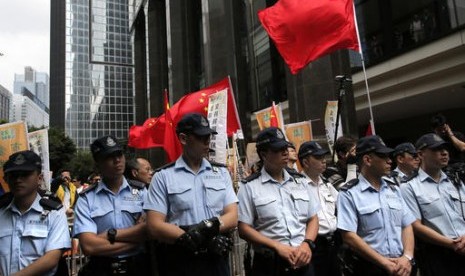 Polisi Hong Kong bersiaga di depan gedung dimana pejabat tinggi Cina Zhang Dejiang memberi sambutan dalam kunjungannya di Hong Kong, Rabu, 18 Mei 2016. 