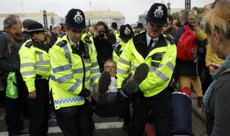 Polisi Inggris menangkap pendemo iklim di jembatan Lambeth di London, Senin (7/10). Pegiat lingkungan memblokir jalan menuju Parlemen Inggris.