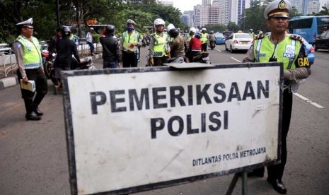 Polisi lalu lintas melakukan tilang terhadap pengendara sepeda motor saat pelaksanaan Operasi Zebra 2013.