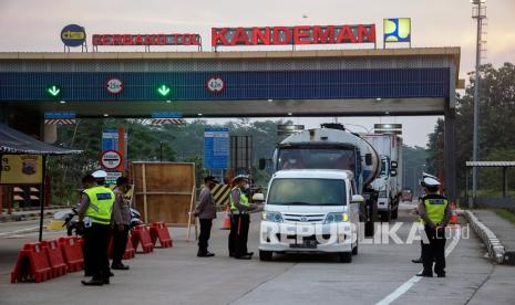 Polisi Lalu Lintas mengecek dokumen perjalanan kendaraan saat penyekatan kendaraan di pintu exit Tol Kandeman, Kabupaten Batang, Jawa Tengah, Jumat (16/7/2021). Polda Jawa Tengah memberlakukan penutupan 27 pintu keluar tol di wilayah Jawa Tengah dengan melakukan putar balik dan penyekatan kendaraan yang tidak dilengkapi dokumen perjalanan kendaraan non esensial dan non kritikal guna membatasi mobilitas masyarakat dalam mencegah laju penyebaran COVID-19.