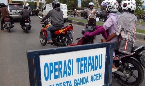  Polisi lalu lintas menghentikan dan memeriksa kelengkapan surat kendaraan ketika berlangsungnya operasi terpadu peningkatan keamanan menjelang pemilukada Aceh di Banda Aceh, NAD.