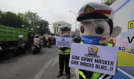 Polisi melakukan imbauan penerapan protokol kesehatan di Jalan Pahlawan, Surabaya, Jawa Timur, Selasa (22/9/2020). Satuan Tugas (Satgas) Penanganan Covid-19 mencatat tempat kerja di Jawa Timur (Jatim) menjadi klaster terbesar penularan virus corona SARS-CoV2 (Covid-19) yaitu sebanyak 31 klaster dengan total 1.082 kasus. 