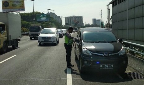 Polisi melakukan penindakan kendaraan yang menggunakan lampu rotator atau sirene di Tol Cawang arah Pancoran, Jakarta Selatan.